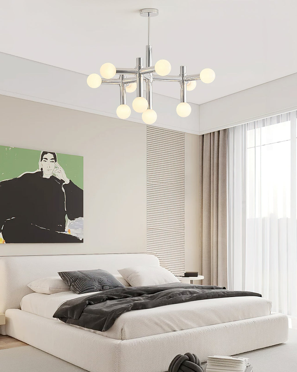 Clérachic chandelier lit in a bedroom with white linens, a green portrait print and sheer curtains at the window.