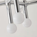 Close view of three frosted glass spheres on polished chrome tube arms, from the underside of this Clérachic chandelier.