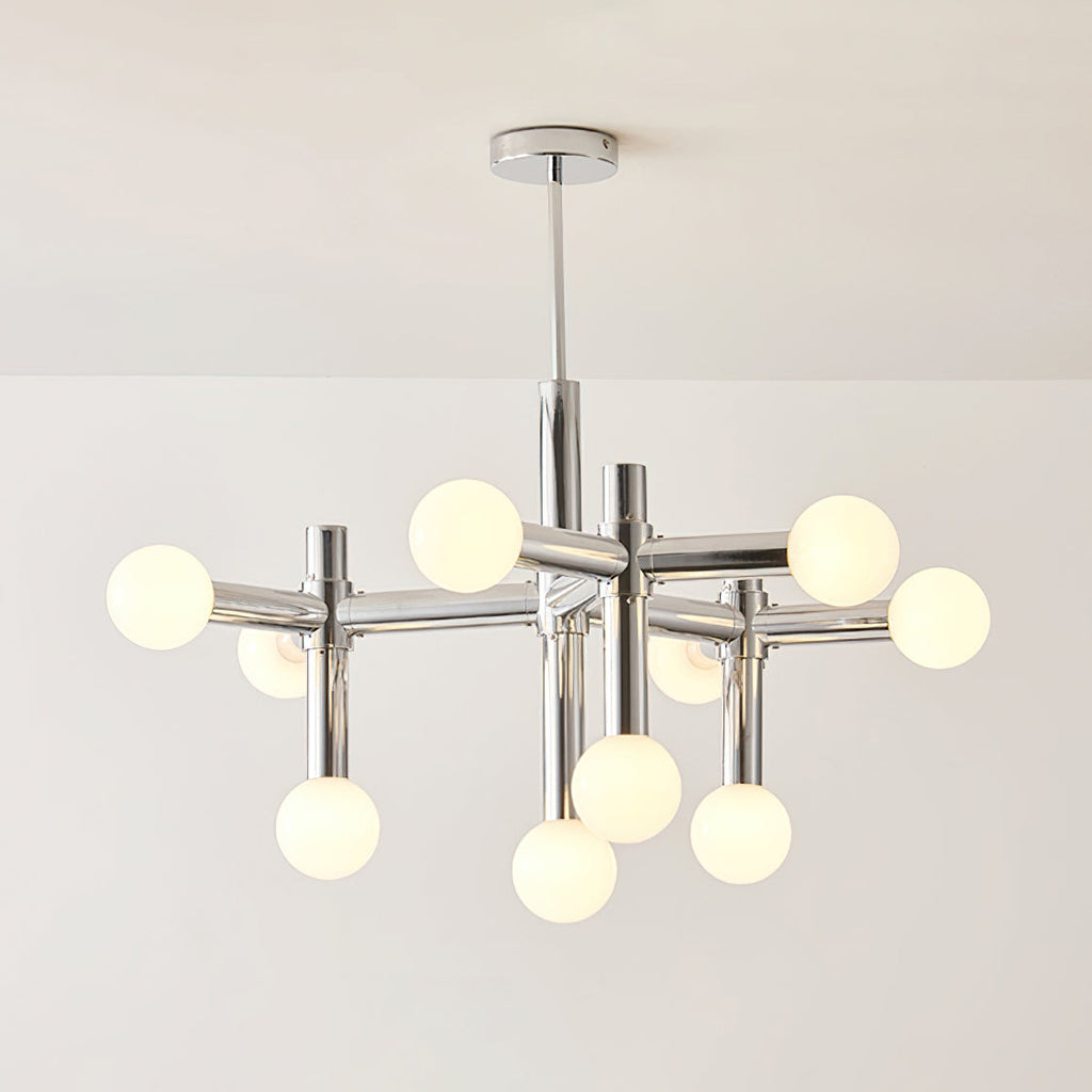 Clérachic chandelier lit warm, the spheres giving off a gentle glow along the polished chrome arms and central stem.