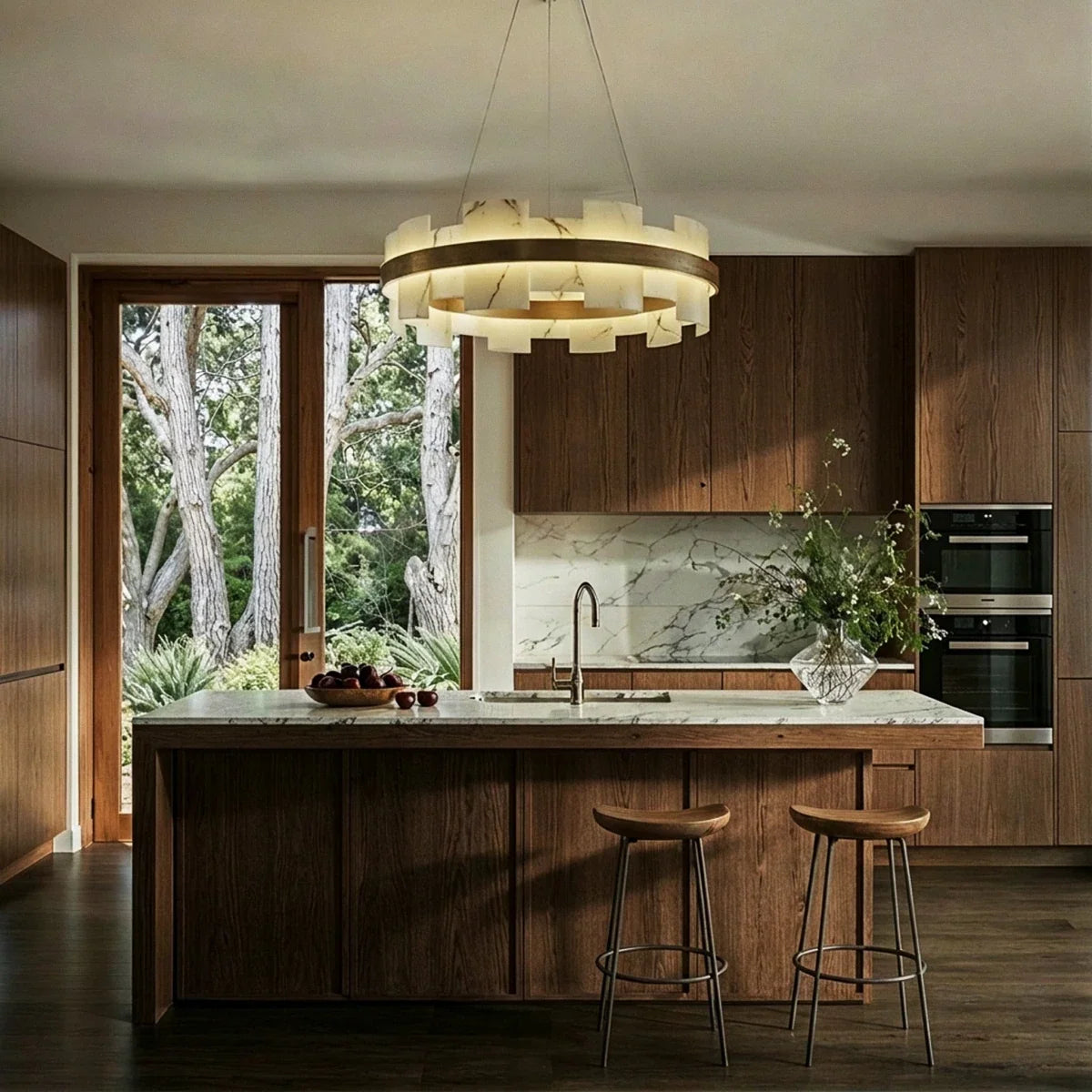 Clérachic circular chandelier of glowing alabaster panels and a brass ring above a timber kitchen island.