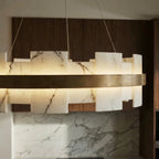 Close crop of Clérachic alabaster panels with dark veining, lit from within and edged with a brushed brass band.