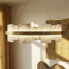 Clérachic chandelier in close view, veined alabaster panels glowing warm above a brass band on fine cables.