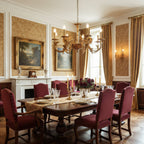 Clérachic brass chandelier above a long dining table with burgundy upholstered chairs, in a room with damask walls.