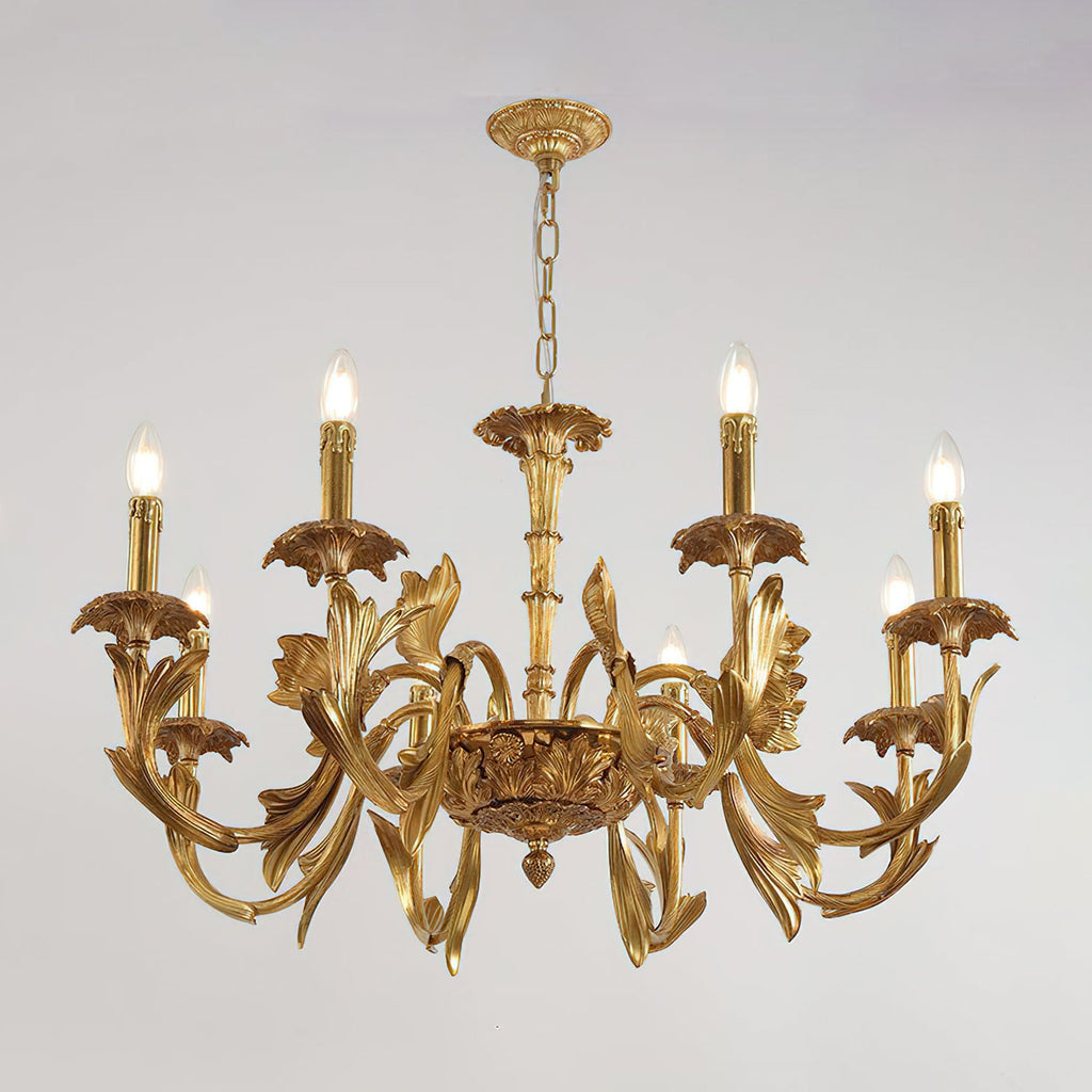 Clérachic brass chandelier lit, hanging from a chain and ornate canopy against a pale grey backdrop.