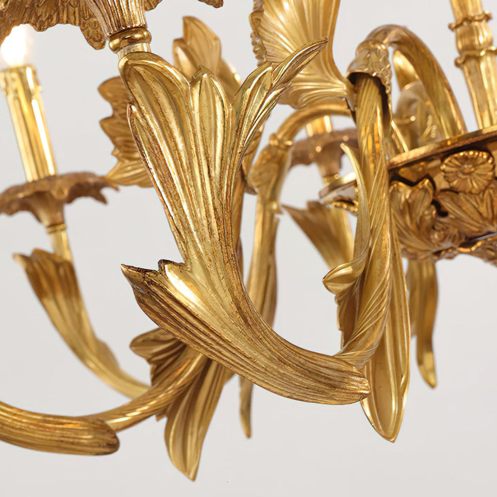 Close view of the sculpted, ribbed brass leaf on one arm of this Clérachic chandelier, with the central bowl beside it.