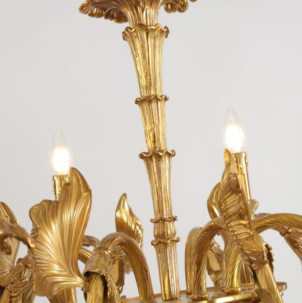 Close view of the reeded brass stem and two lit candle bulbs on this Clérachic chandelier.
