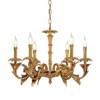 Smaller Clérachic brass chandelier on white, with flame-tip bulbs on curved leaf-shaped arms.