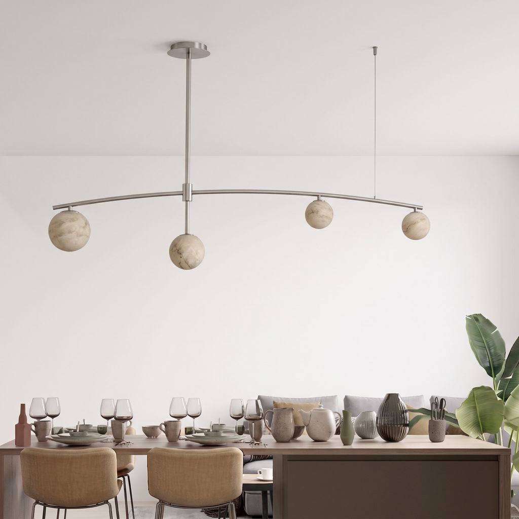 In nickel, this Clérachic chandelier's ball shades line up above a table set for a dinner party.