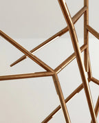 Clérachic close detail of brushed gold chandelier arms, with narrow strips of warm light set into each angular rod.