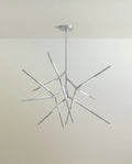 Clérachic branching rod chandelier in polished chrome, angular arms spreading from a slim stem and canopy.
