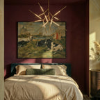 Clérachic gold rod chandelier glowing over a bed in a deep burgundy bedroom, below a large framed painting.