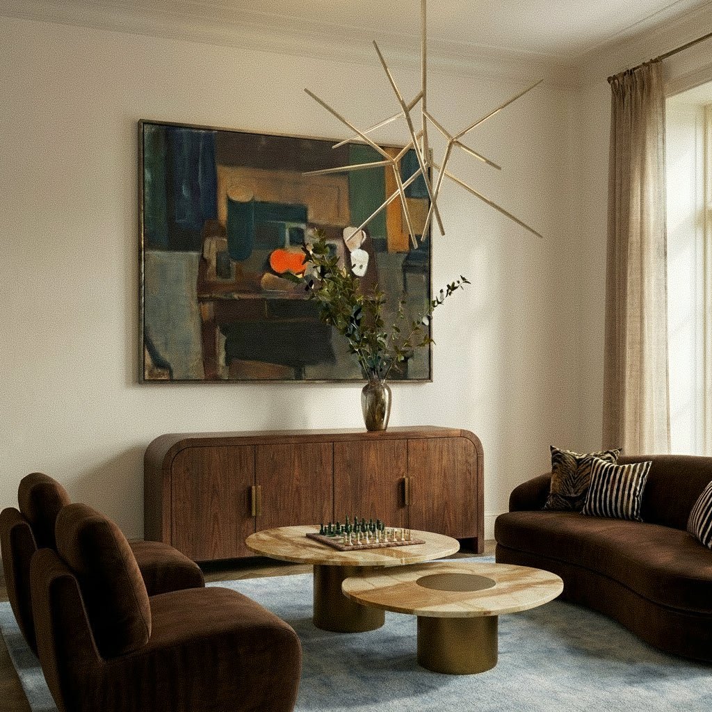 Clérachic pale metal rod chandelier above a sideboard in a living room with brown velvet seating and round marble tables.