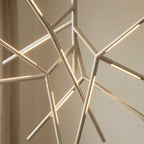 Clérachic close detail of pale champagne metal chandelier rods, with lit strips running along each angular arm.