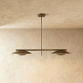 Clérachic chandelier in vintage brass with two angled disc shades suspended from a slim horizontal bar.