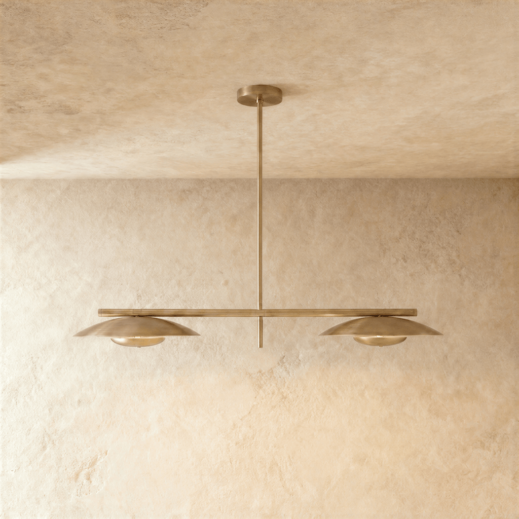 Clérachic chandelier in a warm satin brass finish, twin disc shades hung from a slender bar.