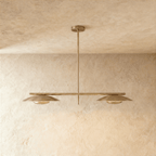 Clérachic chandelier in a warm satin brass finish, twin disc shades hung from a slender bar.