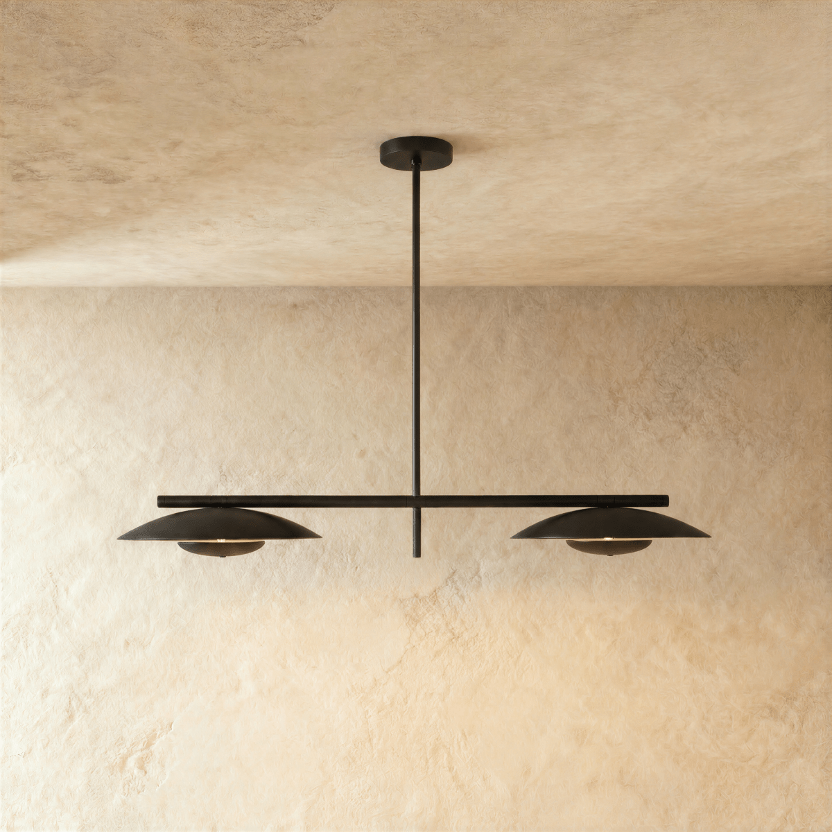 Clérachic chandelier in matte black, two angled disc shades suspended from a slim horizontal bar.