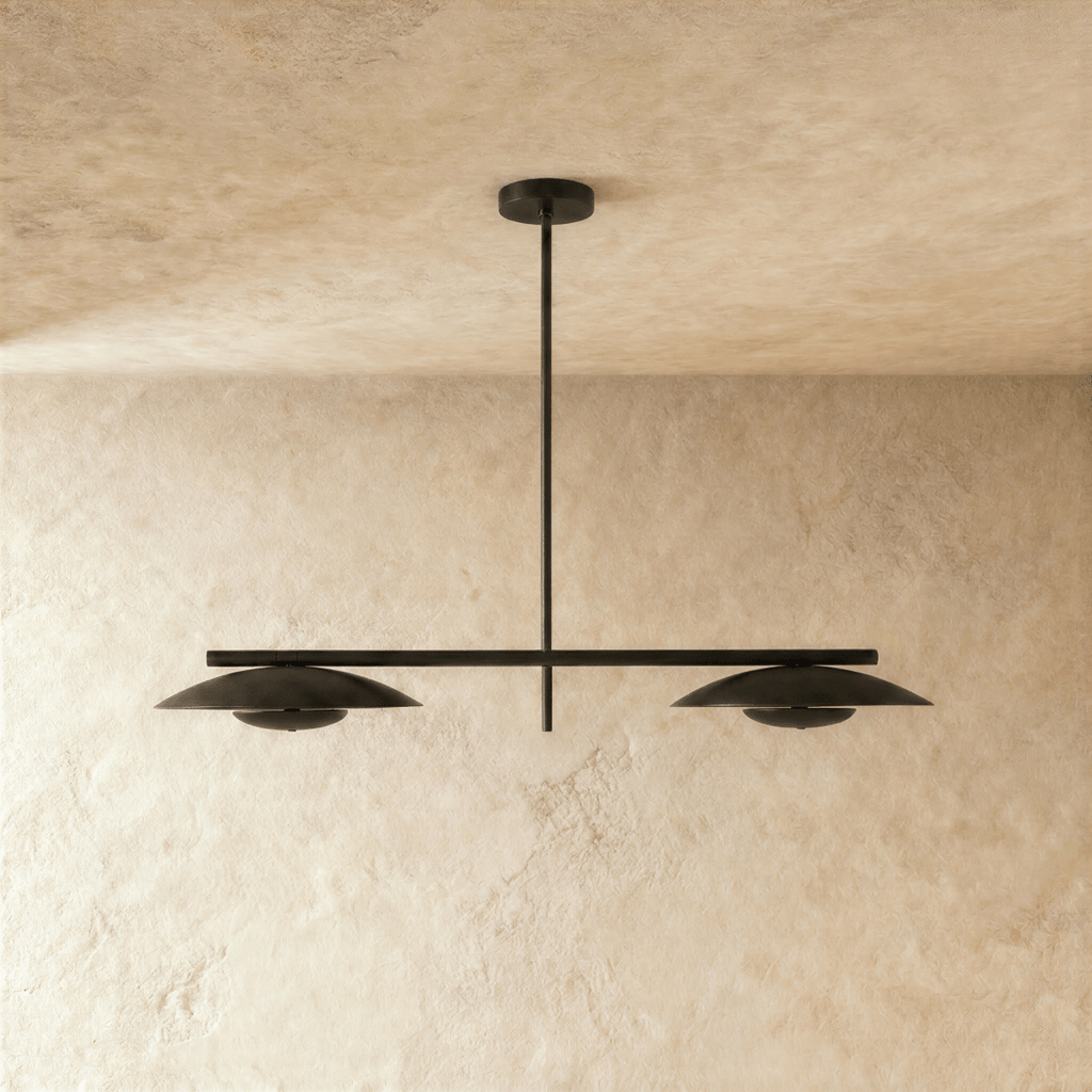 Clérachic chandelier in matte black, front view of the paired disc shades against a plaster wall.