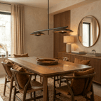 Clérachic chandelier in matte black lighting a dining table beneath a round mirror and taupe walls.