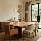 Clérachic chandelier in chrome over a wood dining table with a bronze figurine and glass garden doors.