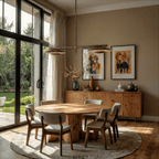 Clérachic chandelier lighting a round wood table beside glass garden doors and a framed dog portrait.