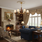 This Clérachic fabric-shade chandelier above a coffee table in a traditional living room with a fireplace and a navy sofa.