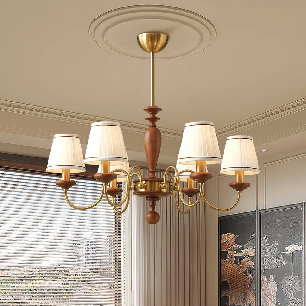 Low-angle view of this Clérachic chandelier under a decorative ceiling rose, its walnut stem and gold arms set against cream walls.