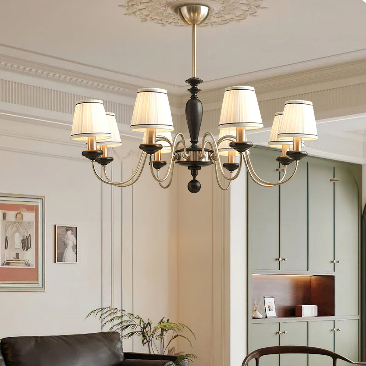 Clérachic chandelier in chrome and black, lit in a pale panelled room with a leather sofa and framed prints.