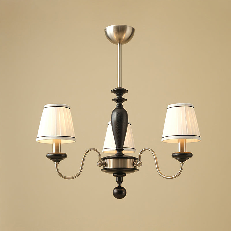 Three-light chrome and black Clérachic chandelier with S-curved arms and a black turned stem, photographed on a beige backdrop.