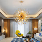 Clérachic gold spike chandelier with bare candle bulbs hung in a living room with a yellow armchair and blue rug.