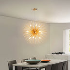 Clérachic gold spike chandelier with candle bulbs hung over a white marble dining table and grey chairs.