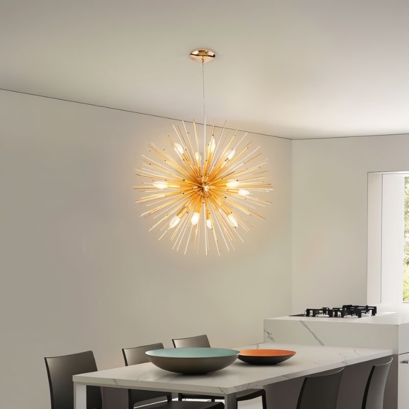 Clérachic gold spike chandelier with candle bulbs hung over a white marble dining table and grey chairs.