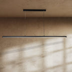 Clérachic slim black linear pendant hung from two fine cables over a textured clay-toned wall, with light along its lower edge.