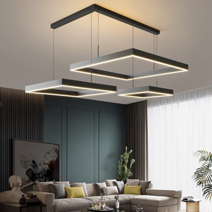 Clérachic three offset black square LED rings at different heights on one ceiling bar above a grey sectional sofa.