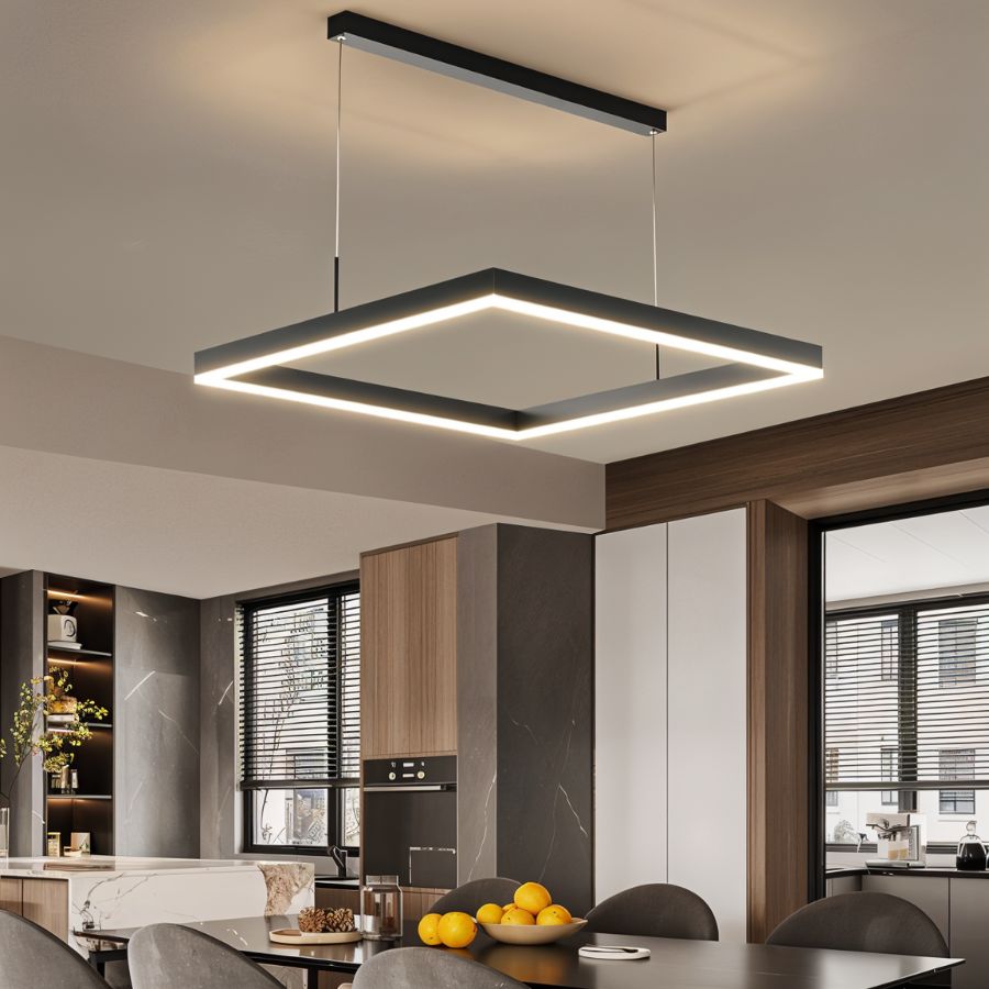 Clérachic single black square LED pendant with a glowing edge, hung over a dining table in an open kitchen.
