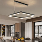 Clérachic single black square LED pendant with a glowing edge, hung over a dining table in an open kitchen.