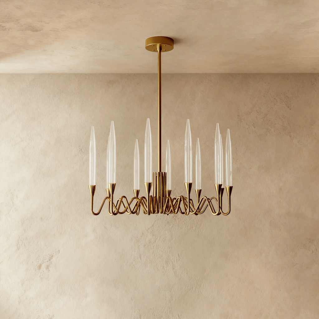 Clérachic round brass chandelier with twelve tapered glass shades on wavy arms, a gold finish against a warm limewash wall.