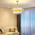 This Clérachic chandelier of brass bars and clear glass rods hangs above a cream sofa, with white calla lilies in the foreground.
