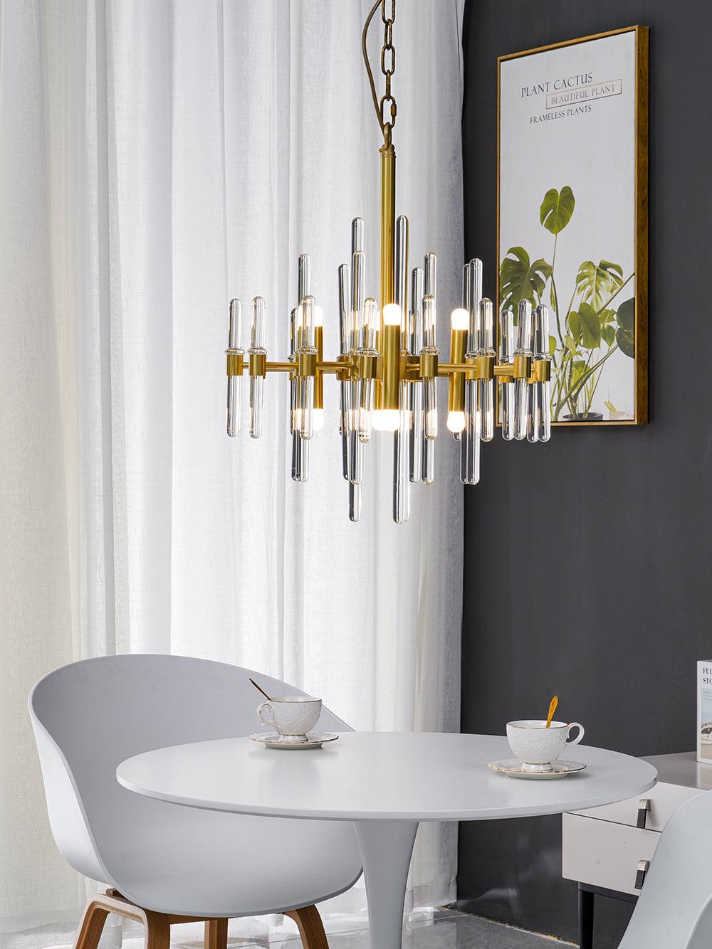 The smaller, slimmer version of this Clérachic chandelier hangs on a chain above a white round table, beside a framed leaf print.
