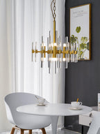 The smaller, slimmer version of this Clérachic chandelier hangs on a chain above a white round table, beside a framed leaf print.