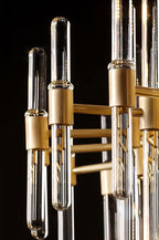 Close view of brass sockets holding clear glass rod ends, with rounded tips, on this Clérachic chandelier against a dark backdrop.