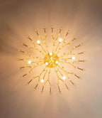 Looking straight up at this Clérachic brass fixture, bulbs and glass-tipped arms radiate from the centre in a sunburst pattern on the ceiling.