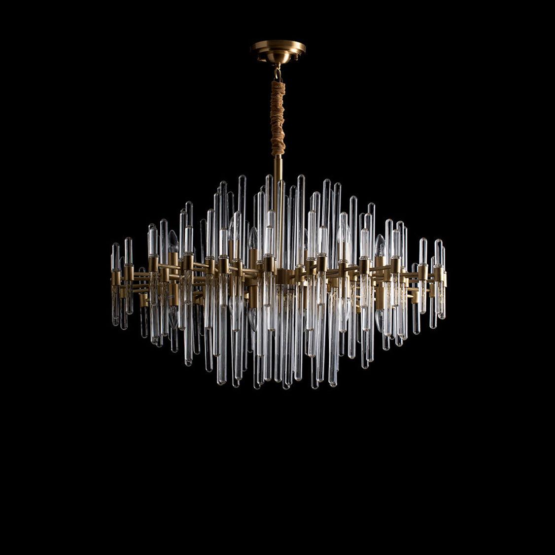 A Clérachic brass chandelier with clear glass rods on black, its rods unlit so the glass shows pale against the dark.