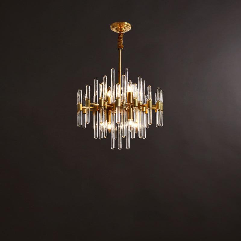 Compact Clérachic chandelier with brass bars and clear glass rods, lit, against a dark brown studio backdrop.