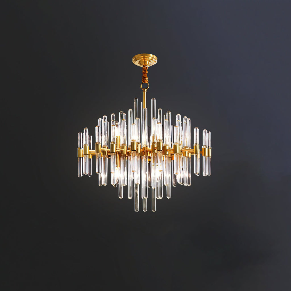 A Clérachic chandelier on a short rod against a dark wall, its brass frame holding clear glass rods of varied lengths.