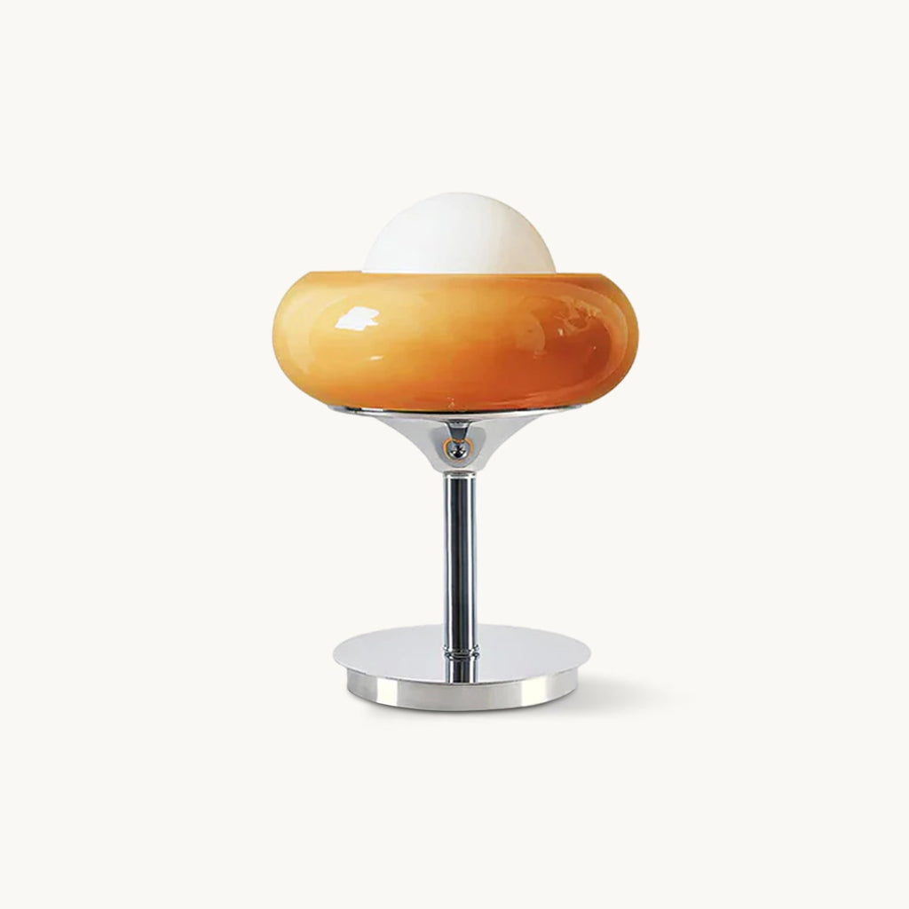 This Clérachic table lamp on a plain backdrop, a rounded amber glass shade with a white globe on top, over a polished chrome stem and round base.