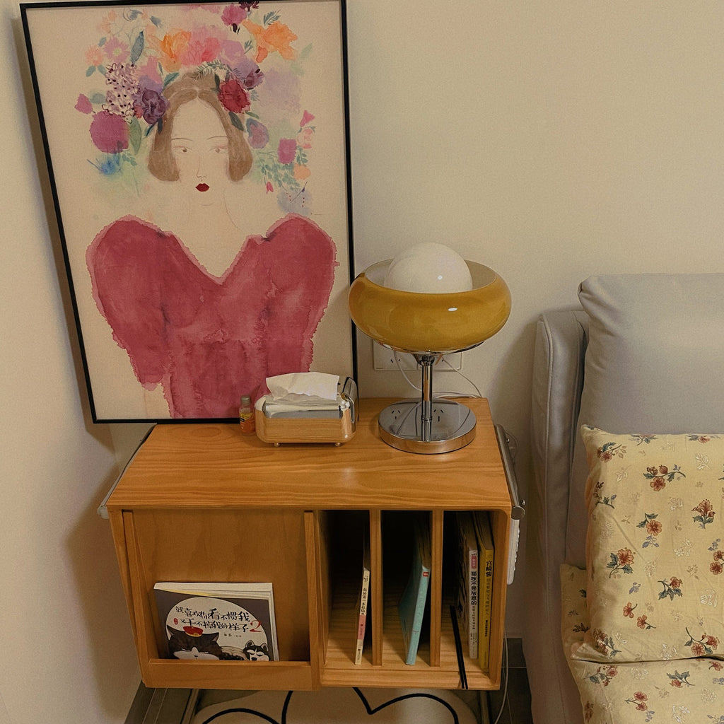 On a wooden wall cabinet below a framed painting, this Clérachic table lamp stands beside a tissue box and a sofa cushion.