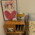 On a wooden wall cabinet below a framed painting, this Clérachic table lamp stands beside a tissue box and a sofa cushion.