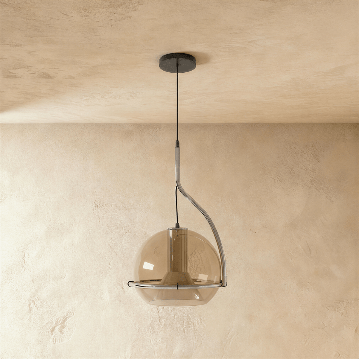 Clérachic pendant light with a smoked amber glass globe and chrome stem, hanging low against a plain plaster wall.