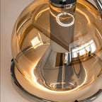Close-up of the Clérachic pendant light's champagne glass dome and chrome ring, showing the warm bulb glowing inside.